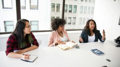 three women in front of desk