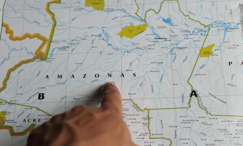 person pointing at the amazonia state on a map