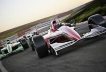 Red race car close up front view on a track leading the pack with motion Blur